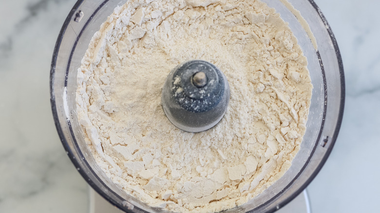 ingrédients de pâte à sec dans un robot culinaire