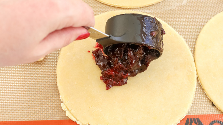 Le remplissage de tarte aux cerises étant mis sur la pâte empanada