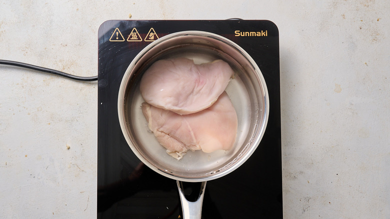 poulet recouvert d'eau en pot