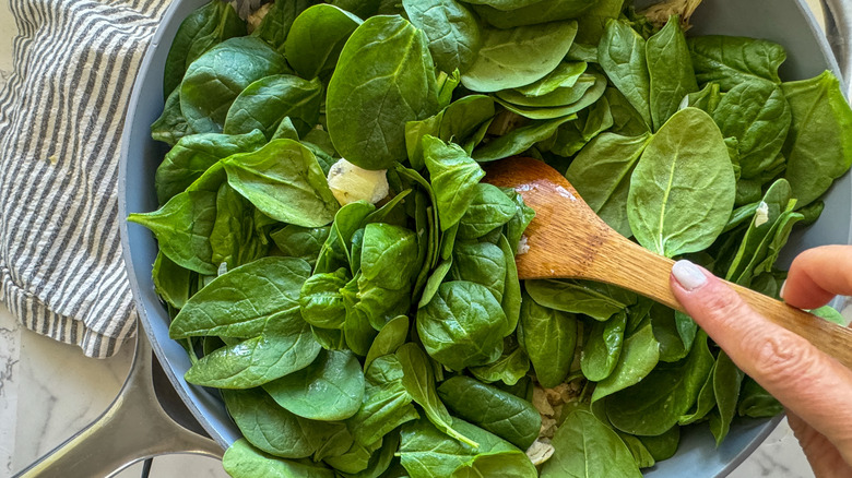 Stimulation à la main pour bébés épinards dans la casserole