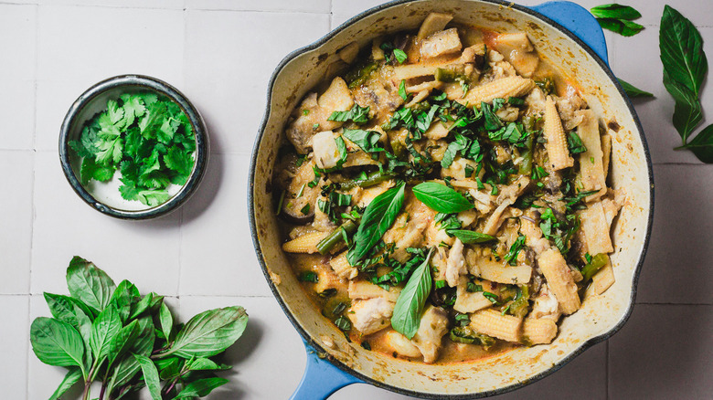 Curry de poisson avec basilic thaï dans une grande casserole