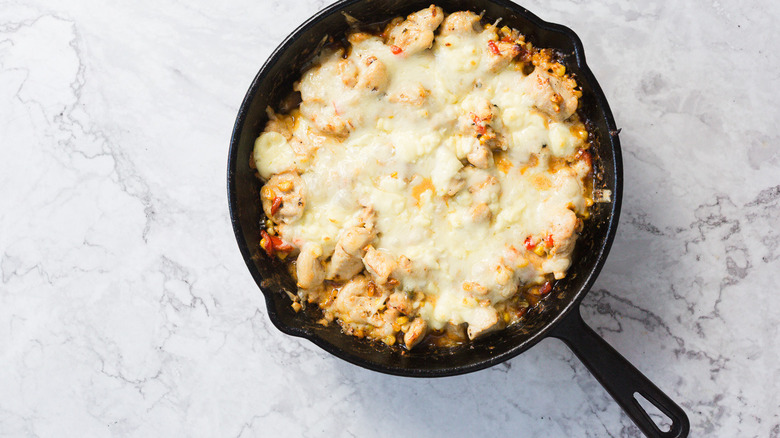 Gros plan sur la poêle de la casserole de maïs de rue et de poulet au fromage