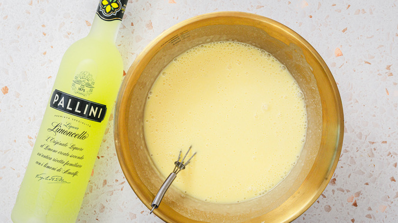 Pâte à crème glacée dans un bol à côté de la bouteille de limoncello