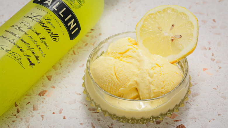 Grosser sur 1 portion de gelato au citron aux côtés de la bouteille de limoncello