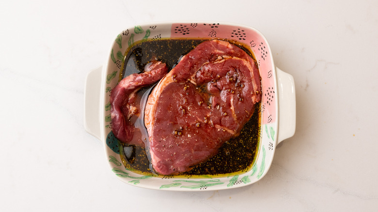 Vue aérienne des steaks marins dans un bol de marinade