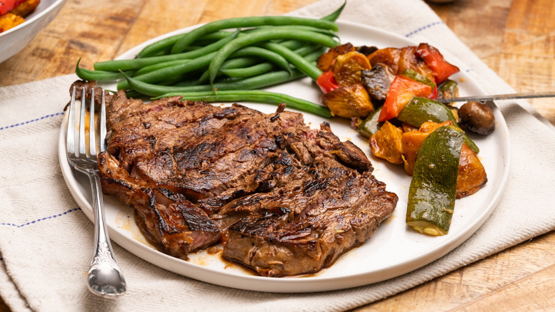 Une assiette de steak cuit avec des légumes sur un nakin