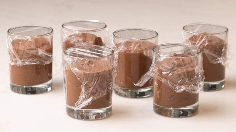 Mousse de chocolat dans des verres recouverts de pellicule plastique
