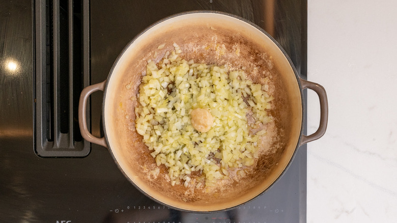 Pan contenant de la pâte d'ail et des oignons en dés cuits
