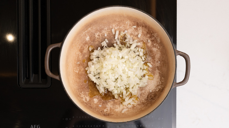 Onion en dés non cuit dans une casserole sur une cuisinière