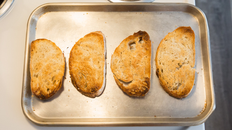 Quatre tranches de pain grillé sur la plaque à pâtisserie