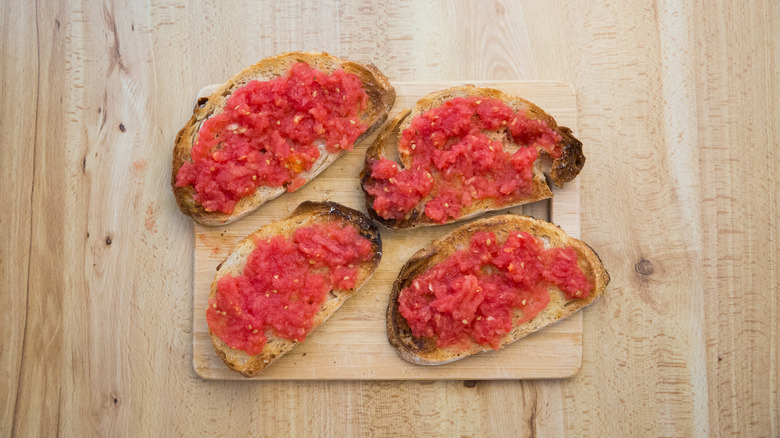 pain à la tomate sur la planche à découper en bois sur une table en bois