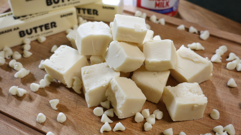Une pile de morceaux de fudge au chocolat blanc sur une planche à découper en bois