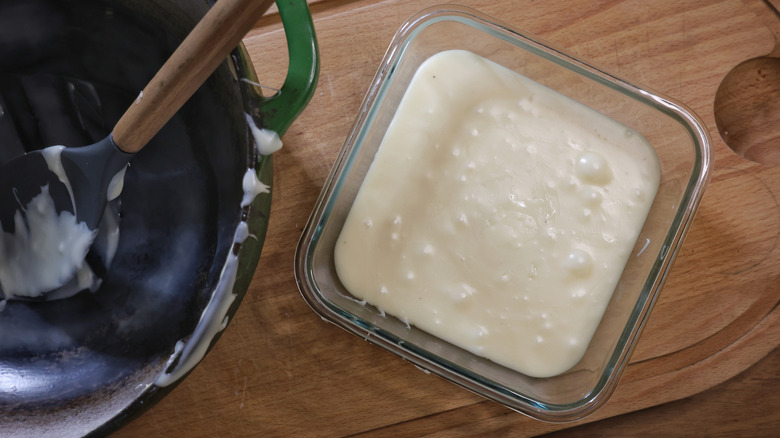 Plat en verre de fudge de chocolat blanc sur planche à découper à côté de la cuillère avec cuillère