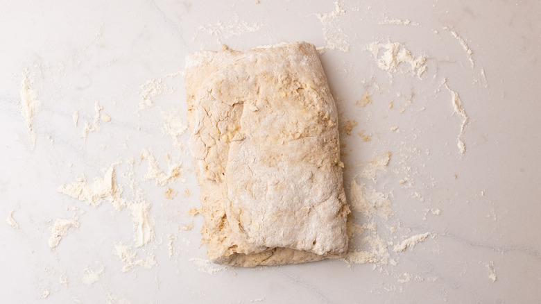 pâte à biscuit pliée à la cannelle sur une surface farinée