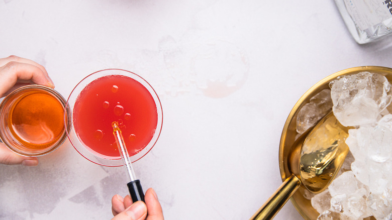 Ajouter de l'huile dans des verres à cocktail.